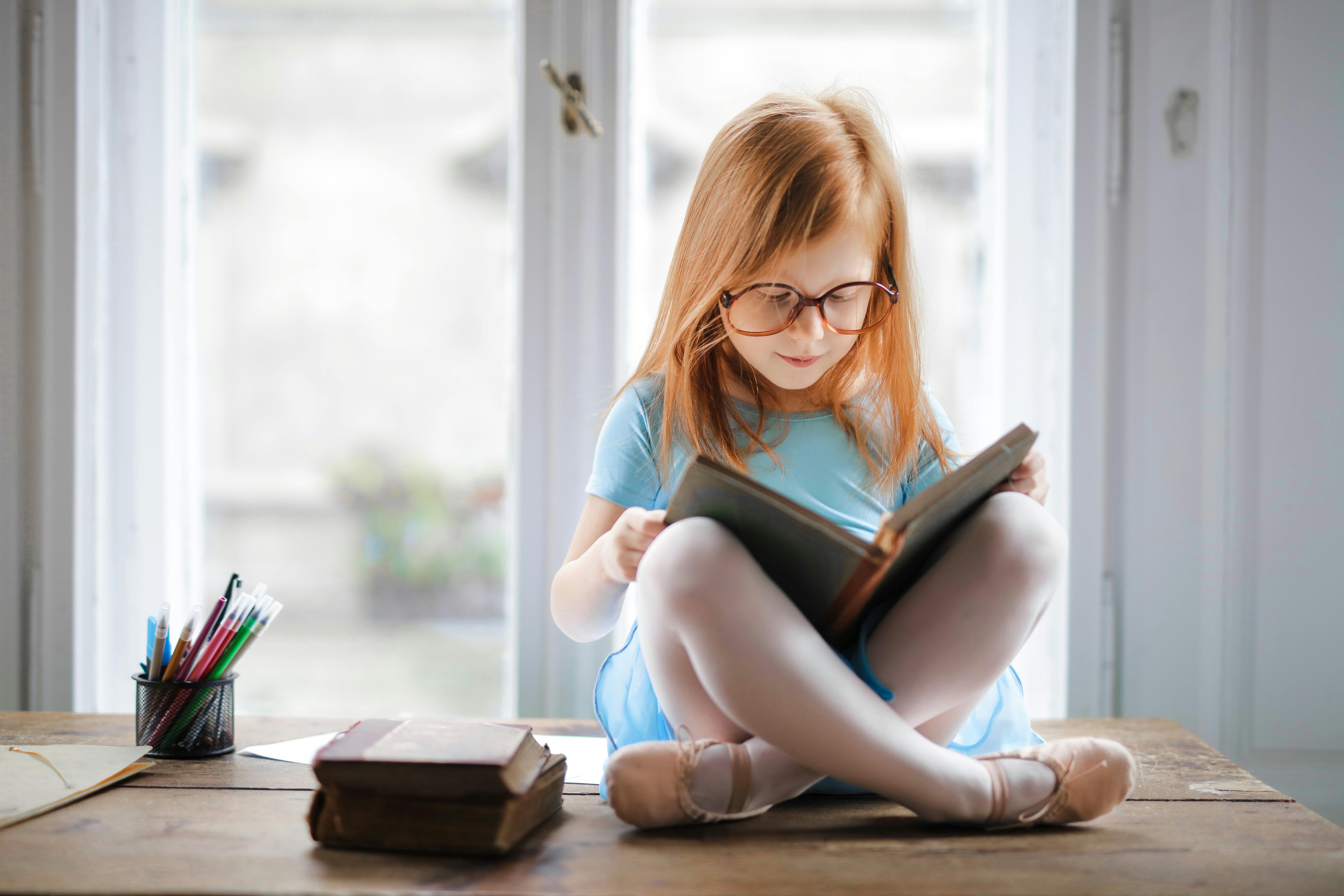 petite fille qui lit attentivement un livre pour enfants