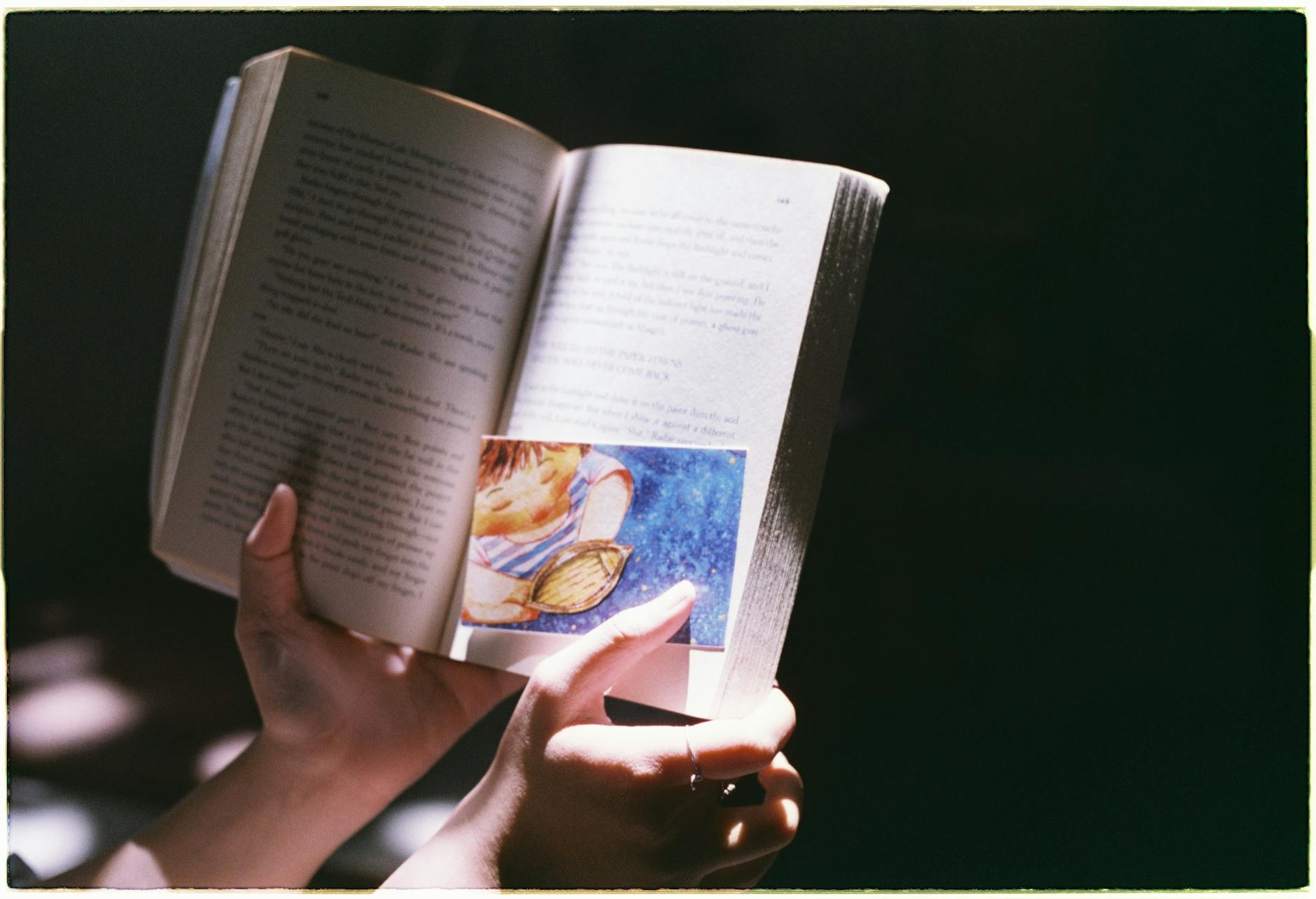 personne qui tient un livre qu'elle a elle même écrit